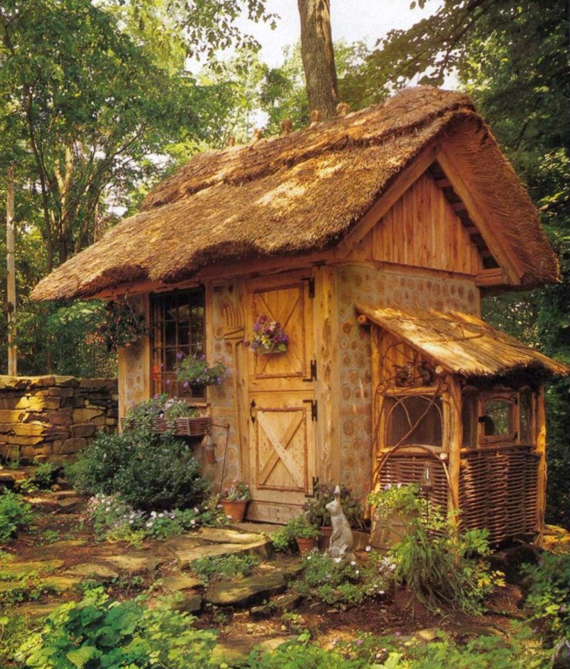cordwood garden shed with a thatched roof and rabbit hutch on the ...