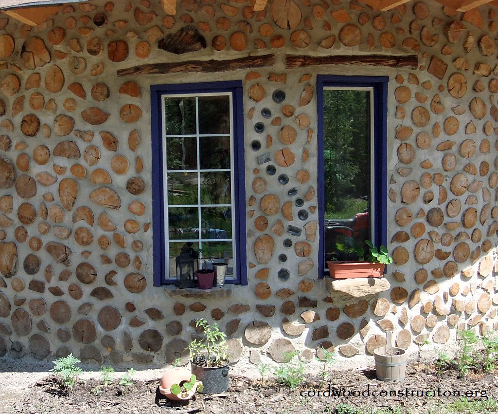 Exterior cordwood wall blue windows small pixels with logo